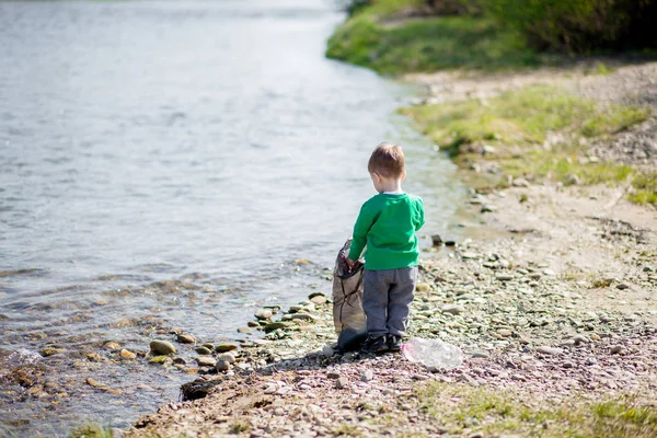 Salva concetto di ambiente, un bambino che raccoglie spazzatura e pl — Foto Stock