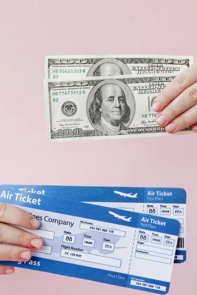 Passaporte, dólares e bilhete de avião na mão de mulher em um fundo rosa. Conceito de viagem, espaço de cópia — Fotografia de Stock