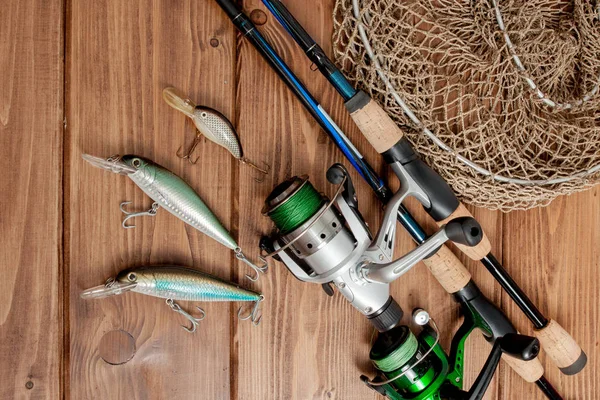 Aparejos de pesca - spinning de pesca, anzuelos y señuelos en bac de madera — Foto de Stock