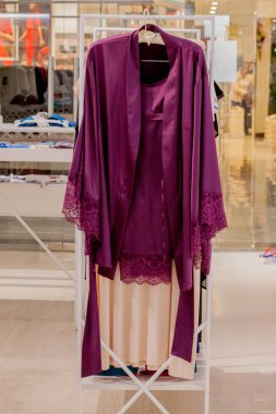 Mağazada kadın kırmızı saten gecelik. Reklam, Satış, Moda konsepti.