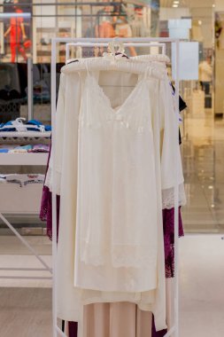 Mağazada kadın kırmızı saten gecelik. Reklam, Satış, Moda konsepti.