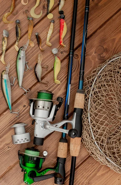 Рыболовные снасти - прядение рыбы, крючки и приманки на деревянном фоне с копировальным пространством — стоковое фото