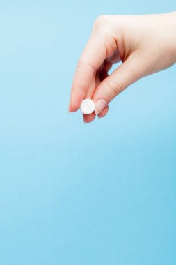 Yakın çekim shot bir ilaç üzerinde mavi arka plan izole hemşire'nın elinde. Kopya alanı