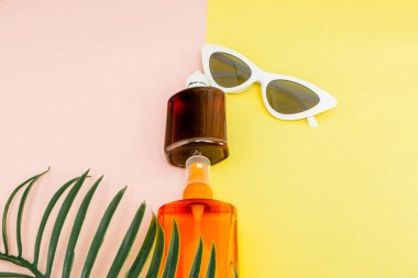 Parlak kare sarı ve pembe arka planda şişe güneş kremi. Bu,