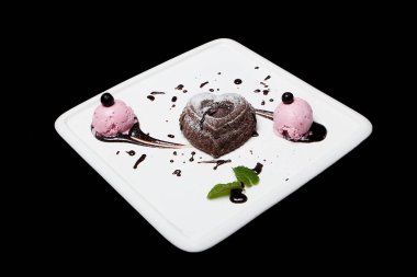 Tatlı fondan çikolata siyah bir zemin üzerine beyaz bir plaka üzerinde dondurma ile. Enfes Fransız çikolata tatlı fondan, metin için yer