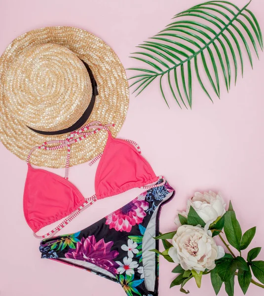 Hut, Badeanzug und Sonnenbrille auf rosa Hintergrund. von oben, flach — Stockfoto