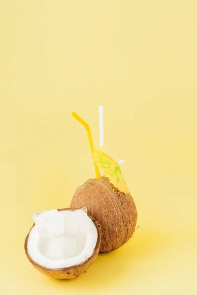 Coctel de coco fresco con pajitas sobre fondo amarillo, copiado — Foto de Stock