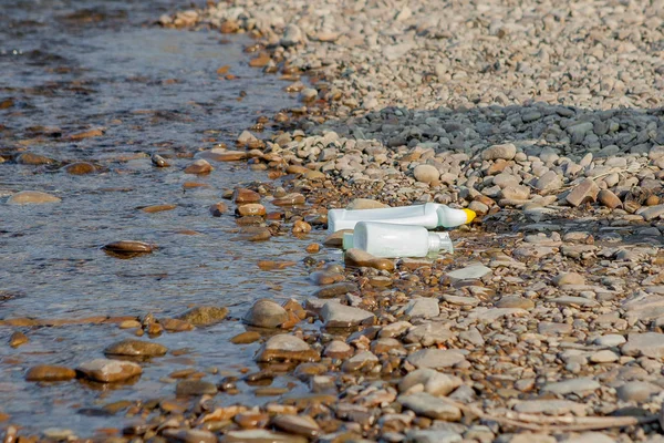 River pollution near the shore, garbage near the river, plastic food waste, contributing to pollution