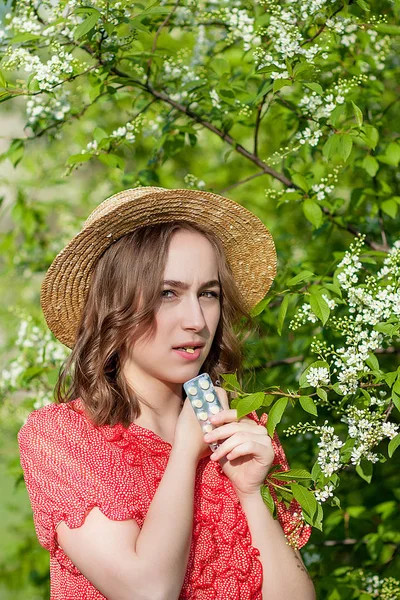 Ung flicka blåser näsa och nysningar i vävnad framför Blom — Stockfoto