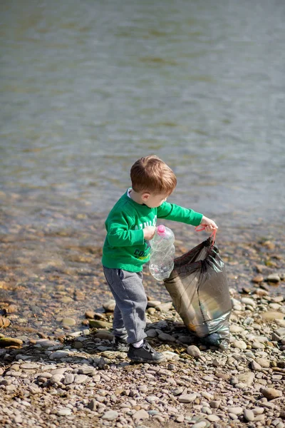 Salva concetto di ambiente, un bambino che raccoglie spazzatura e pl — Foto Stock