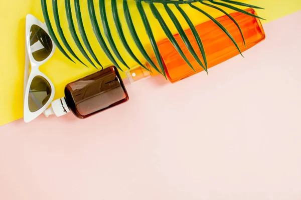 Flasche Sonnenschutz auf hellem quadratischen gelben und rosa Hintergrund. das Konzept des Seebades, Sommerzeit. Draufsicht, flache Lage, Minimalismus, Kopierraum — Stockfoto