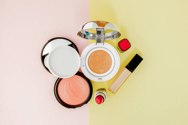 Make up products spilling on to a bright yellow and pink backgro