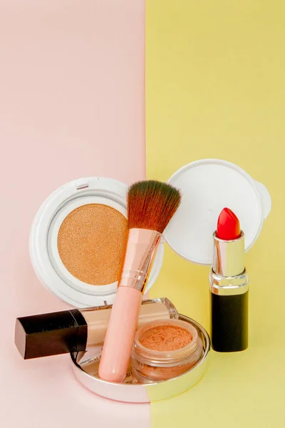 化妆产品洒在明亮的黄色和粉红色的后沟 — 图库照片