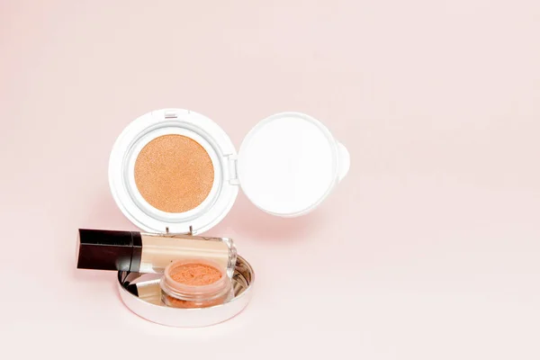 Make up prodotti versando su uno sfondo rosa brillante con co — Foto Stock