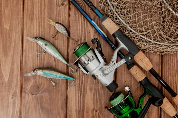 Риболовецька голка - риболовля, прядіння, гачки та приманки на дерев'яному фоні з копіювальним простором — стокове фото