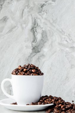 Mermer arka planda fincan ve kahve çekirdekleri siyah kahve. En iyi v