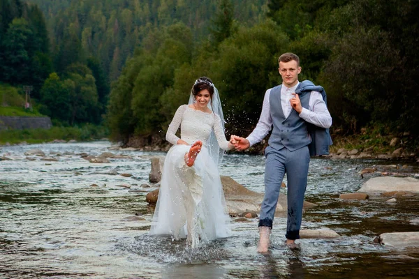 Felizes recém-casados de pé e sorrindo no rio. Lua de mel, foto para o Dia dos Namorados — Fotografia de Stock