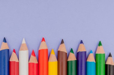 Menekşe arka plan üzerinde renkli kalemler projeleri ve duyurular için