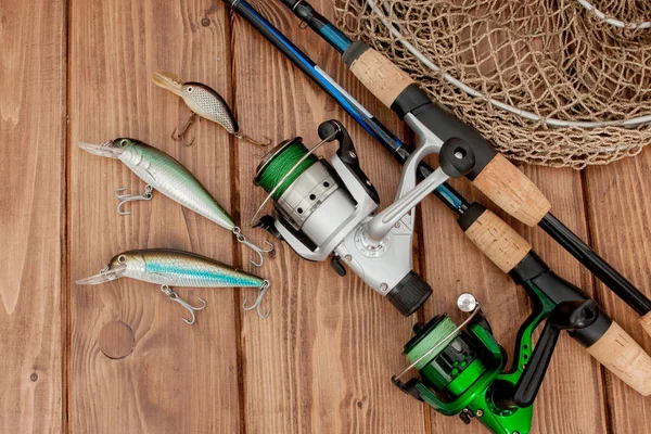 Fiskeredskap-fiske spinning, krokar och beten på trä bakgrund med kopierings utrymme — Stockfoto