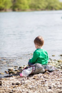 Çevre kavramı kaydedin, küçük bir çocuk çöp toplama ve pl