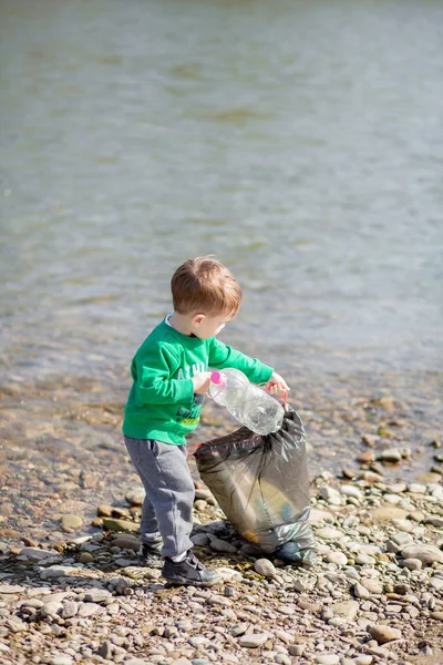 环保理念，一个小男孩收集垃圾和 — 图库照片