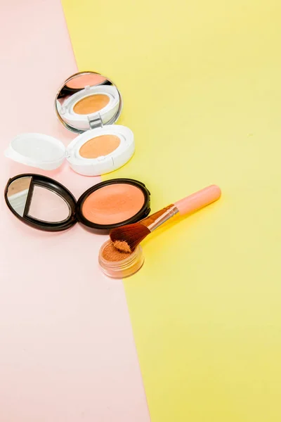 Make up prodotti versando su uno sfondo giallo brillante e rosa con spazio copia — Foto Stock