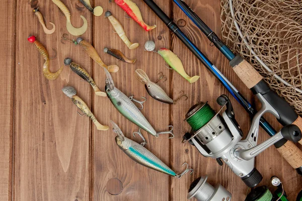 Рыболовные снасти - прядение рыбы, крючки и приманки на деревянном фоне с копировальным пространством — стоковое фото