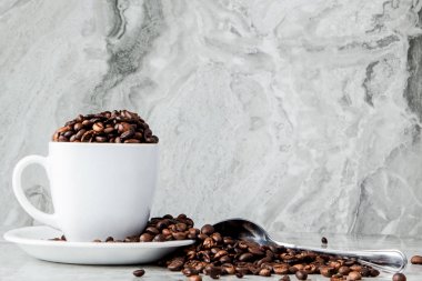 Mermer arka planda fincan ve kahve çekirdekleri siyah kahve. En iyi v