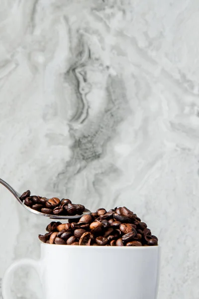 Black coffee in cup and coffee beans on marble background. Top view, space for text — Stock Photo, Image