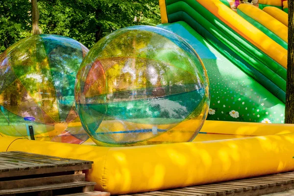 Aqua zorbing. Colorful water walking balls. Water activity for kids. Children playing together and having fun inside large inflatable sphere in a pool