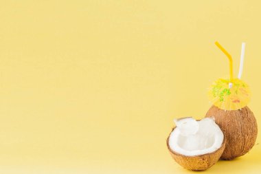 Sarı arka planda bir pipet ile taze Hindistan cevizi kokteyli