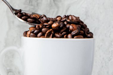 Mermer arka planda fincan ve kahve çekirdekleri siyah kahve. En iyi v