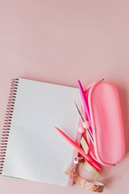 Okula geri dön. Pembe arka plan üzerine kalem ve kalem ile defter, kalem kasa