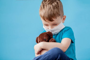 Cute little boy using nebulizer on blue background. Allergy conc clipart