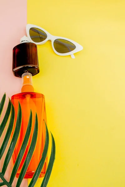Flasche Sonnenschutz auf hellem quadratischen gelben und rosa Hintergrund. die — Stockfoto
