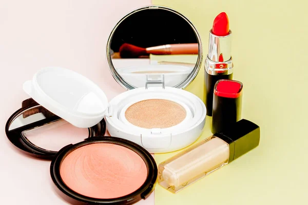 Make up produtos derramando em um backgro amarelo e rosa brilhante — Fotografia de Stock