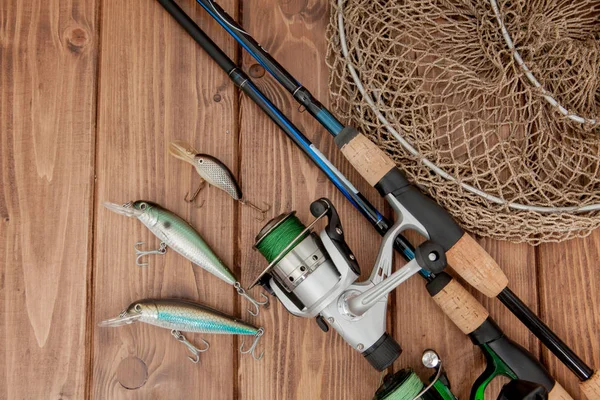 Fiskeredskap-fiske spinning, krokar och beten på trä bakgrund med kopierings utrymme — Stockfoto