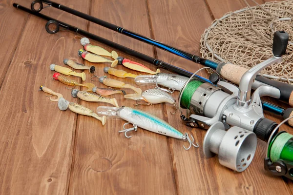 Aparejos de pesca - spinning de pesca, anzuelos y señuelos sobre fondo de madera con espacio para copiar — Foto de Stock