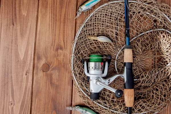 Aparejos de pesca - spinning de pesca, anzuelos y señuelos en bac de madera — Foto de Stock