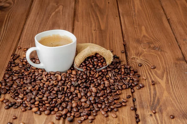 Coffee cup with coffee bag on wooden table. View from top