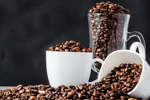 Black coffee in white cup and coffee beans on black background. — Stock Photo, Image