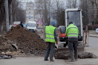 Kiev, Ukrayna - 22 Şubat 2019: Komün yansıtıcı özel yelekler içinde yol işçilerden bir grup görüşüyorlar acil bir durum ne zaman borular kaçağı ortadan kaldırmak için bir delik kazma