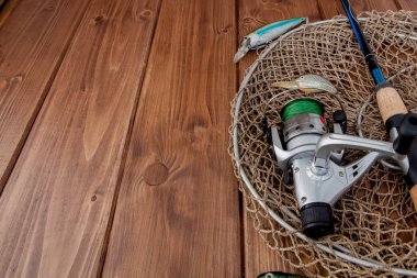 Kyiv, Ukraine - February 22, 2019: Fishing tackle - fishing spinning, hooks and lures on wooden background with copy space