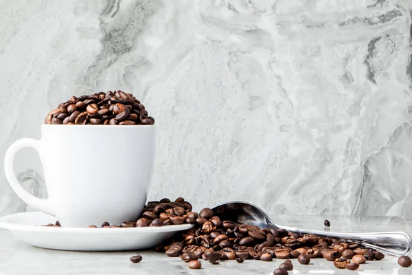 Black coffee in cup and coffee beans on marble background. Top v — Stock Photo, Image
