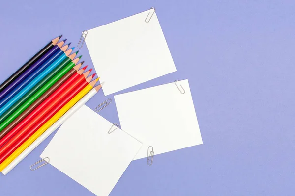 Hoja en blanco de papeles y lápices de color sobre fondo violeta para Proyectos y Anuncios, espacio de copia — Foto de Stock
