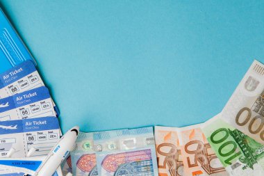 Pasaport, dolar ve Euro, uçak ve hava bileti mavi bir arka üzerinde