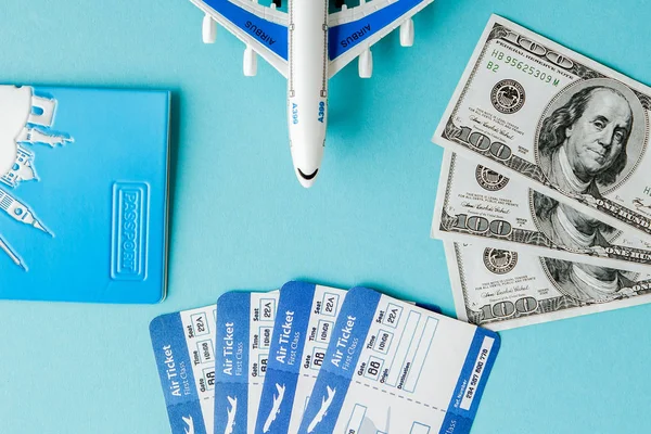Paspoort, dollars, vliegtuig en lucht ticket op een blauwe achtergrond. Tr — Stockfoto