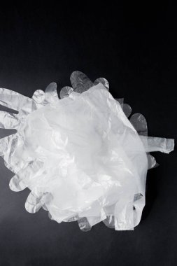 Siyah bir arka planda kolları, eldiven, plastik torba. İkinci el p
