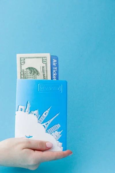 Pas, dolary a letenku v ženské ruce na modrém pozadí. Cestovní koncept, kopírování místa — Stock fotografie