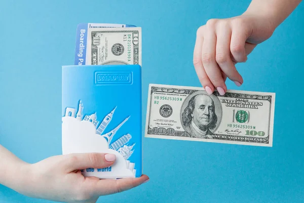 Paspoort, dollars en vliegticket in Woman hand op een blauwe backgro — Stockfoto
